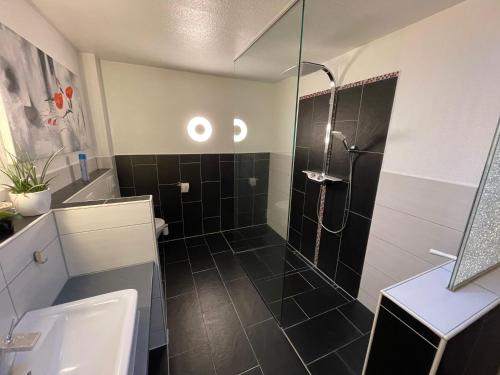 La salle de bains est pourvue d'une douche avec une porte en verre. dans l'établissement Kingfisher-Ferienhaus, à Westerdeichstrich