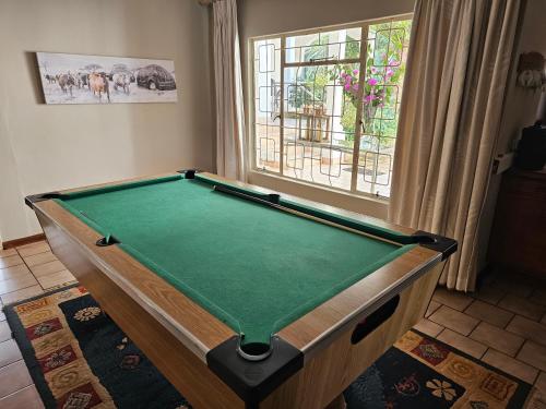 a pool table in a room with a window at Pecan Farm Guesthouse in Louis Trichardt