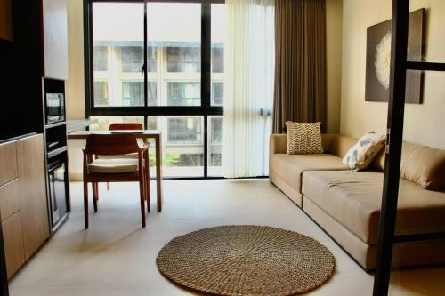 a living room with a couch and a table at Cozy Minimalist Apartment Lavaya N511 in Nusa Dua