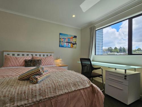 a bedroom with a bed and a desk and a window at Gazeley Gem in Hamilton