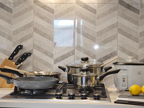 two pots and pans on a stove in a kitchen at Gazeley Gem in Hamilton