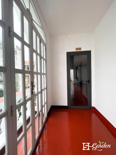an empty room with doors and a red floor at 5H Garden in Ho Chi Minh City