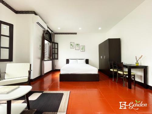a bedroom with a bed and a table and chairs at 5H Garden in Ho Chi Minh City
