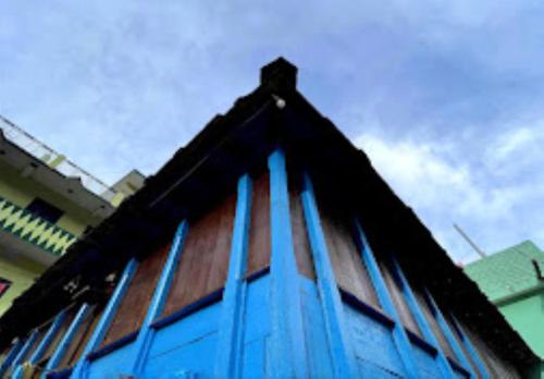 een gebouw met blauwe ramen aan de zijkant bij YATRA HOMESTAY Joshimath in Joshimath