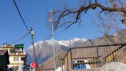 una bandera en un poste con montañas en el fondo en YATRA HOMESTAY Joshimath, en Jyotirmath