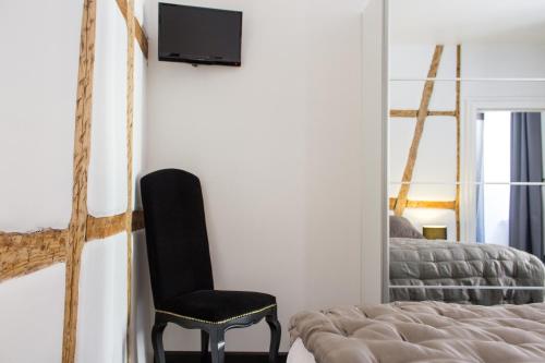 a bedroom with a bed and a chair and a mirror at MY SWEET HOMES - Appartements avec SPA in Colmar