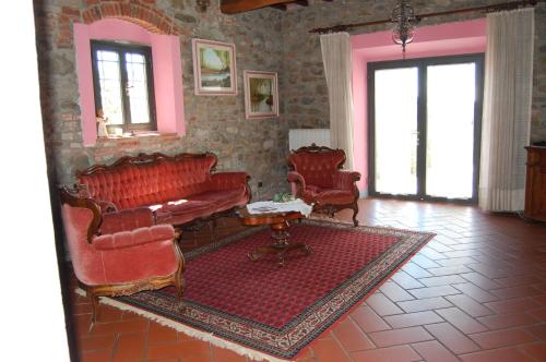 a living room with red chairs and a table at Fattoria Antognoni in Reggello