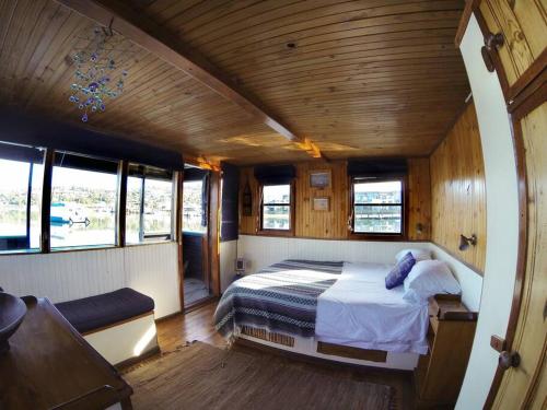 um quarto com uma cama no meio de um barco em Knysna Houseboat Myrtle em Knysna