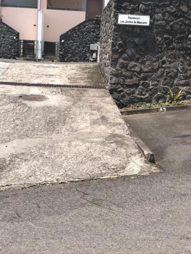 a concrete sidewalk next to a building with a sign on it at Studio 14 proche GRR2 97400 in Saint-Denis