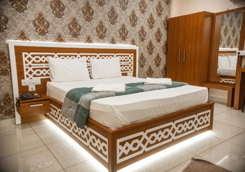 um quarto com uma cama grande e uma estrutura em madeira em Emerald Royal Residency em Cochin