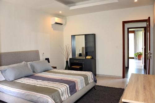 una camera con letto, tavolo e specchio di 2 Bedroom Villa with Pool & Close to Setangi Beach a Mangsit