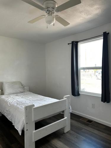 a bedroom with a bed with a ceiling fan and a window at Near Red Mountain park in Mesa