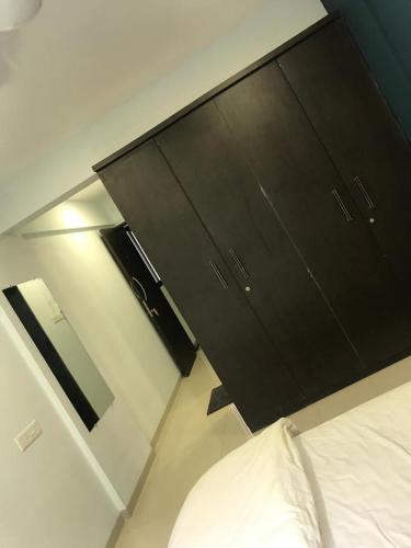 um quarto com uma cama e uma cómoda preta em Hooliv 7 Avenues G Block em Pune