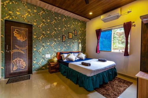 ein Schlafzimmer mit einem Bett und einer Wand mit Blumen in der Unterkunft Lifeline Villas - Miracle Villa 5bhk Valley View in Mahabaleshwar