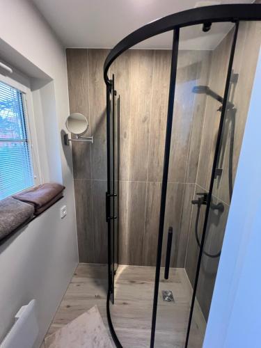 a shower with a glass door in a bathroom at Une-min in Nida