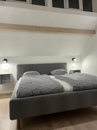 uma cama com lençóis e almofadas preto e branco em Une-min em Nida