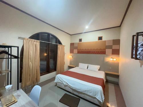 a hotel room with a bed and a window at The Pancas Homestay in Rantepao