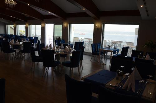 a dining room with tables and chairs and windows at Elite Hotels Darica Spa & Convention Center in Gebze