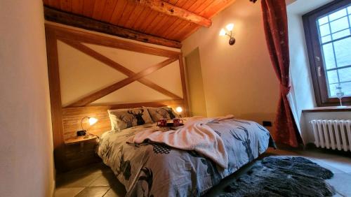a bedroom with a bed with a wooden ceiling at Baita 3 lovely & central Sauze in Sauze dʼOulx
