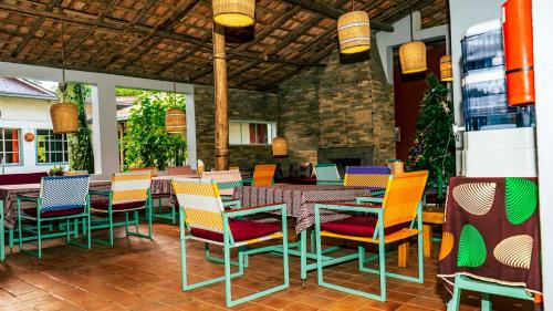 a patio with colorful chairs and tables in a restaurant at Isange Paradise Resort in Ruhengeri