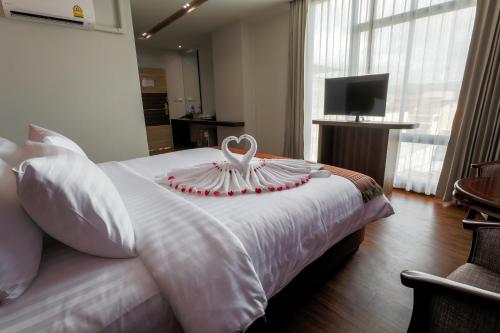 a bedroom with a white bed with a heart on it at Grandpink park hotel in Hat Yai