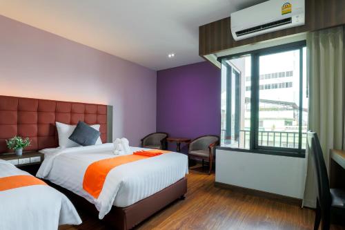a hotel room with a bed and a window at Grandpink park hotel in Hat Yai