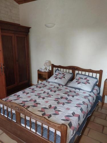 a bed with a quilt on it in a bedroom at La maison du bonheur in Beaumes-de-Venise