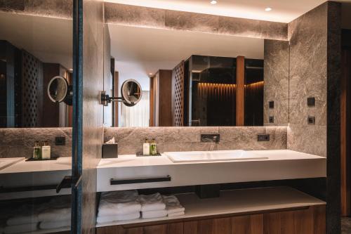 Un baño con dos lavabos y un espejo grande. en Residence Chalet L'Salvan, en Selva di Val Gardena