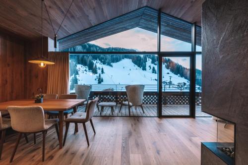 a dining room with a table and chairs and a large window at Residence Chalet L'Salvan in Selva di Val Gardena