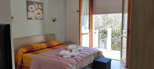 1 dormitorio con 1 cama con toallas en APPARTAMENTI RIMINI NEL CUORE, en Rímini