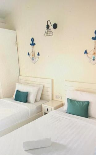 two beds sitting next to each other in a room at Renovated 2 Bedroom Seavilla for 6pax in Pantai Cenang