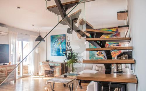 a living room with a spiral staircase and a table at AMARA Family & Surf with Oceanview and Pool in Tarifa