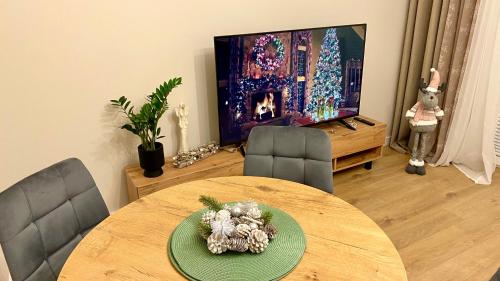 a living room with a table and a television at Apartament GREEN CROWNS in Płock
