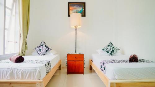 En eller flere senge i et værelse på Dormitory Tourism Sritanjung Banyuwangi with Ijen Tour By Celcius