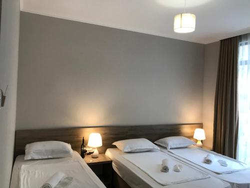 two beds in a hotel room next to a window at Nina two in K'obulet'i