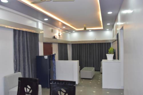 a meeting room with chairs and a ceiling with lights at Leela Homestay Indore - Tulip - 2 BHK Luxury apartment in Indore