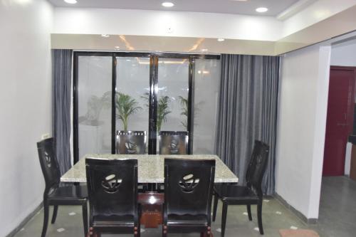 a dining room with a table and chairs at Leela Homestay Indore - Tulip - 2 BHK Luxury apartment in Indore