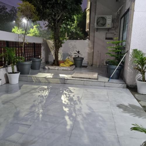 a patio with potted plants and a tree at Leela Homestay Indore - Tulip - 2 BHK Luxury apartment in Indore