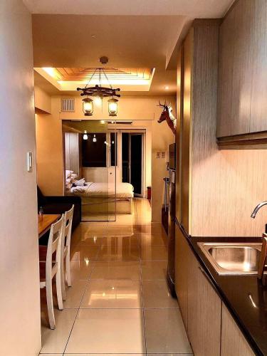 a kitchen with a sink and a room with a bed at Wind Suites in Tagaytay