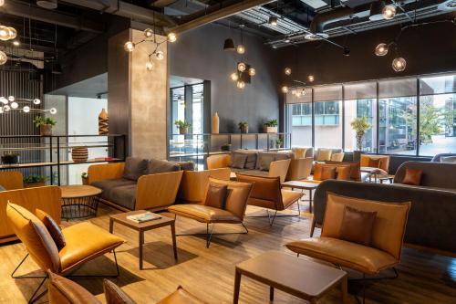 a waiting room with couches and chairs and tables at INNSiDE by Meliá Liverpool in Liverpool