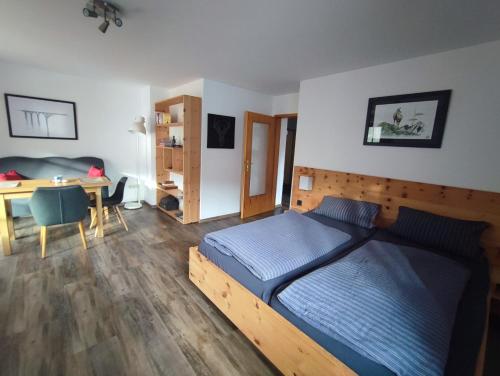 Schlafzimmer mit einem Bett, einem Schreibtisch und einem Tisch in der Unterkunft Apartment Kofel Aussicht in Oberammergau