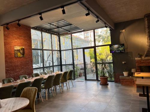 a restaurant with tables and chairs and a large window at Nina two in K'obulet'i