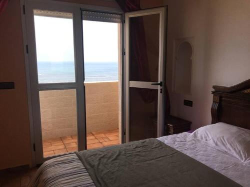 a bedroom with a bed and a view of the ocean at Asilah beach Apartment seaview in Asilah