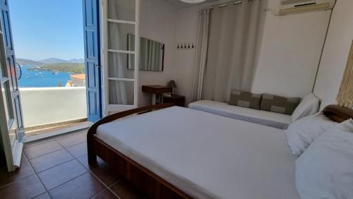1 dormitorio con 2 camas y vistas al océano en Panoramic View apartment, en Poros