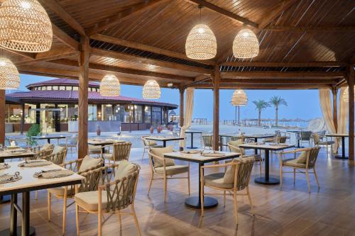 a restaurant with tables and chairs and a view of the ocean at True Beach Resort in Marsa Alam City
