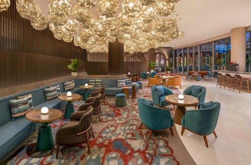 a lobby with tables and chairs and a chandelier at W Singapore - Sentosa Cove in Singapore