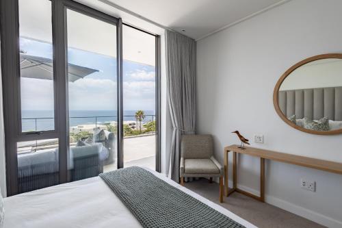 a bedroom with a view of the ocean at Plett Quarter Apartments in Plettenberg Bay