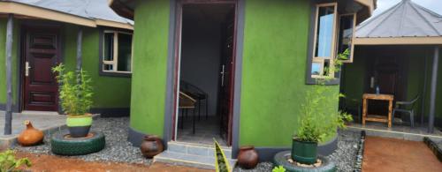 a green house with plants in pots in front of it at Amanya 3-Bedroom Hut Amboseli in Amboseli