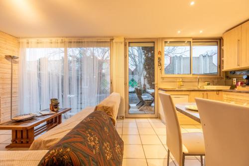 a kitchen and living room with a couch and a table at Appartement avec jardin, idéal pour animaux - Floréal in Clermont-Ferrand