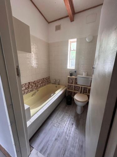 uma casa de banho com uma banheira, um WC e um lavatório. em Joyful Creation em Middelburg